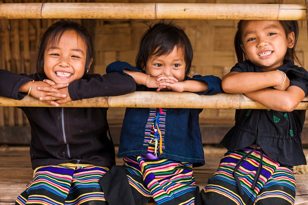 Three little girls having fun in the village in Northern Laos.