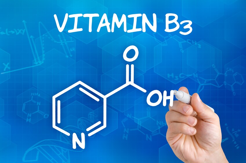 Hand with pen drawing the chemical formula of Vitamin B3