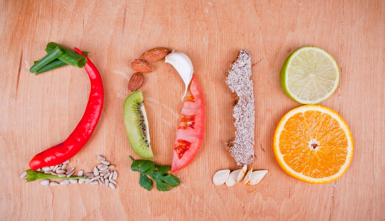 A composition of healthy food fruit, vegetables, brown bread, seeds and herbs which make 2018 number.