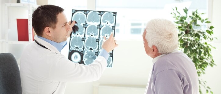 Senior man at doctor's office. Doctor analyzing a CT scan of head
