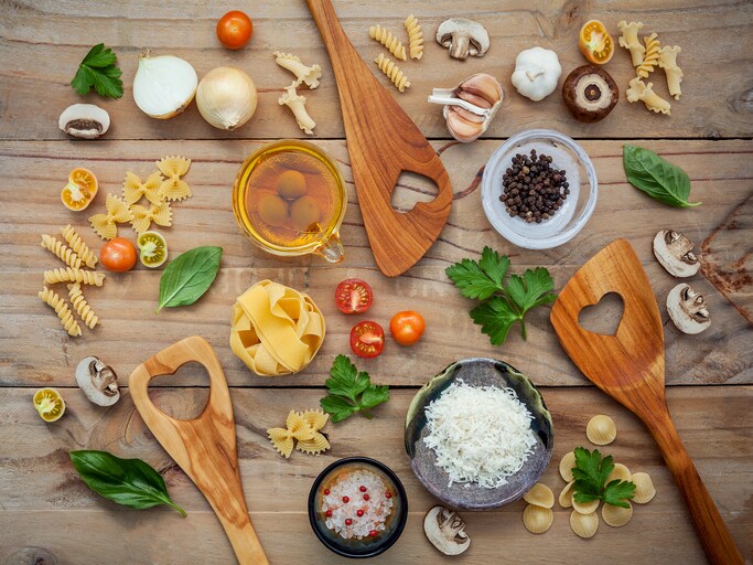 Italian foods concept and menu design.Various kind of pasta with ingredients sweet basil ,tomato ,garlic ,parsley ,champignon and extra virgin olive oil on wooden background flat lay.