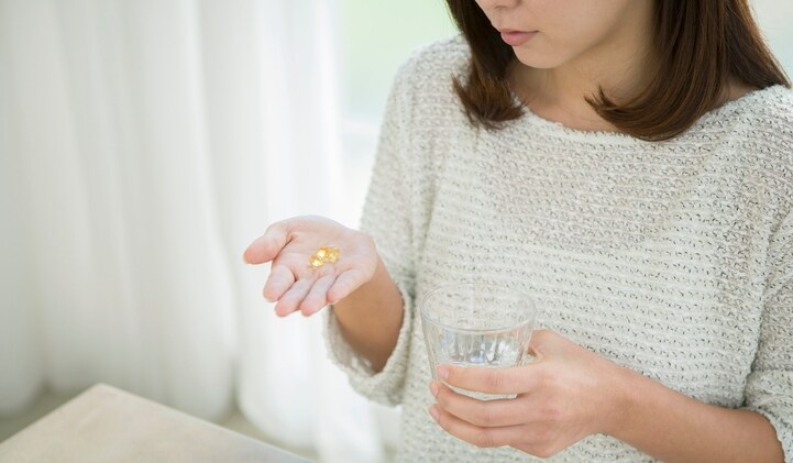 Woman taking CoQ10 supplements