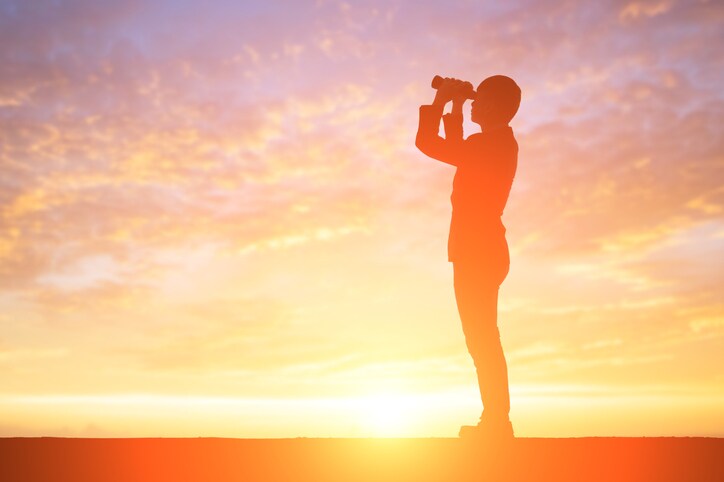 silhouette of business man take binocular telescope with sunset