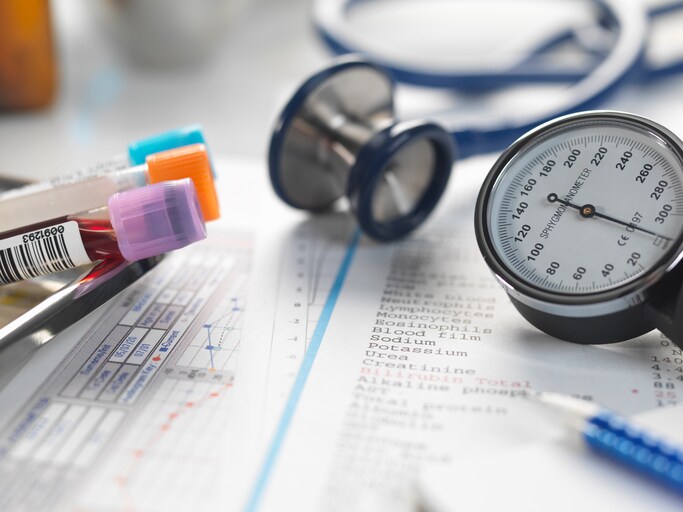 Doctors desk with patients test results, samples, stethoscope and blood pressure gauge